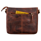 Damenhandtasche aus echtem Leder in cognac mit einem befüllten Reißverschlussfach auf der Rückseite